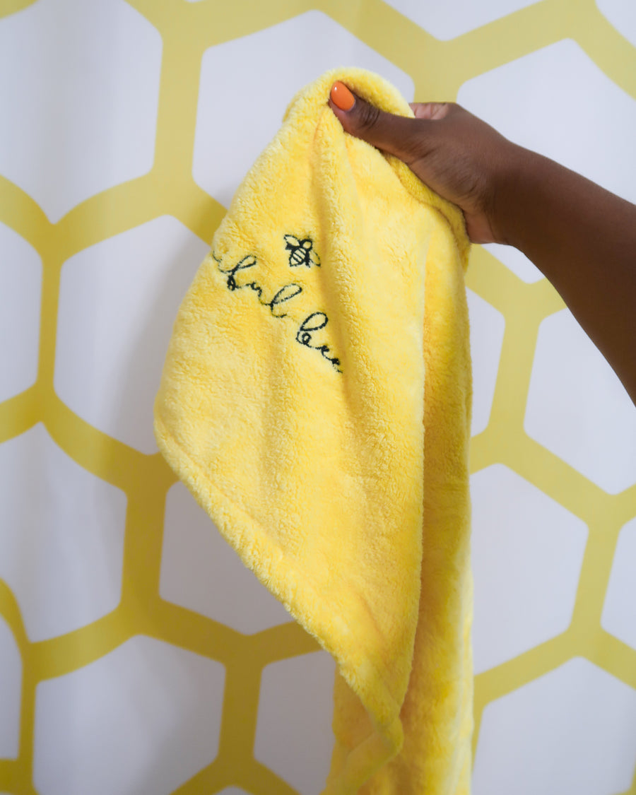 yellow microfiber hair towel in hand